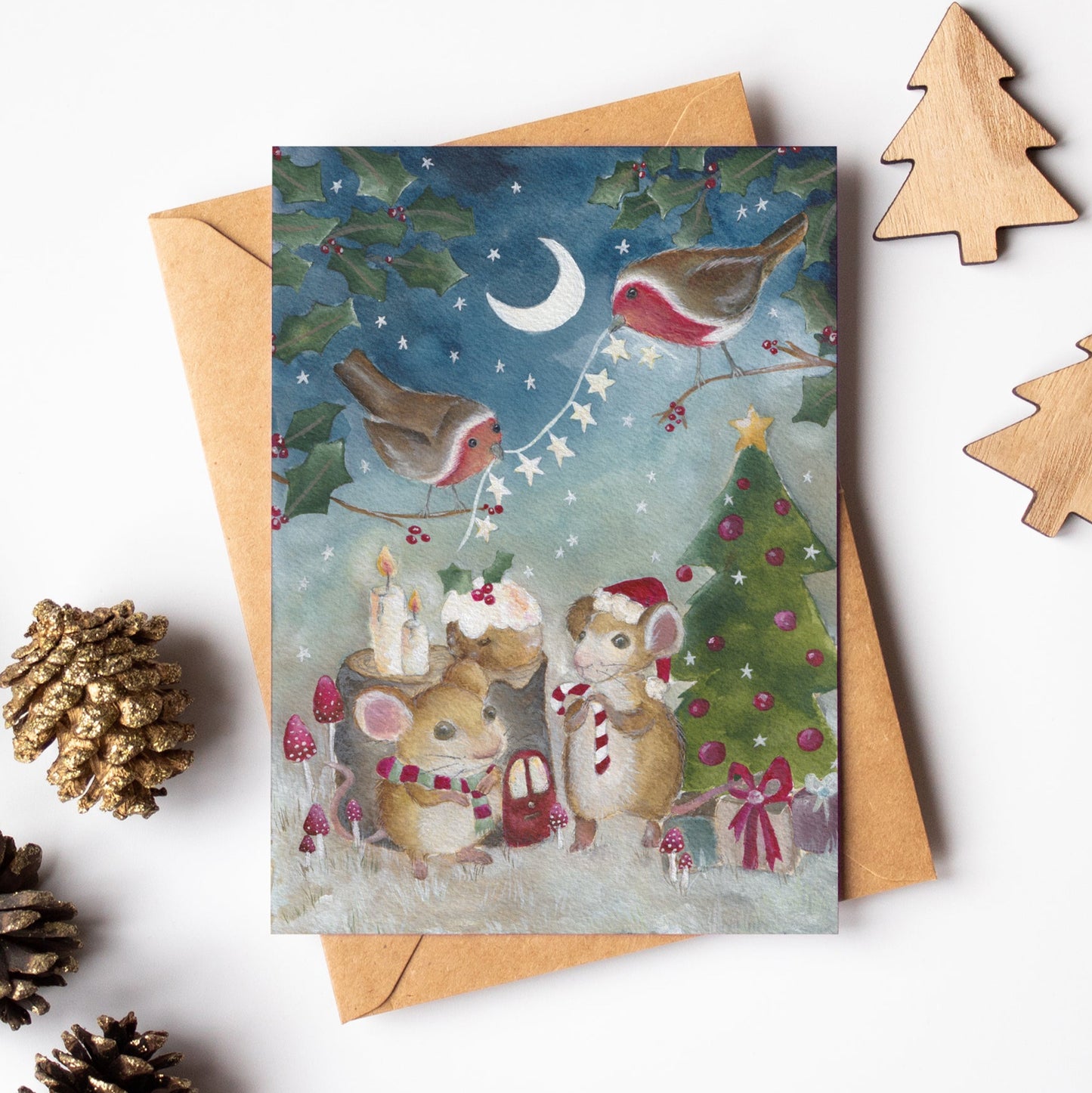 Christmas-themed greeting card with animals and a tree, surrounded by decorative items on a white background.