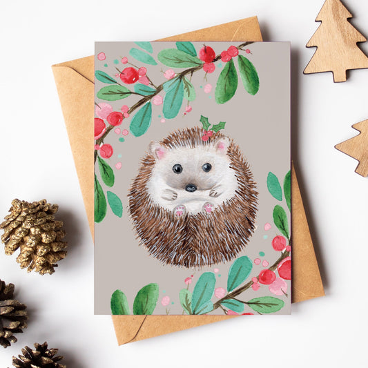 Greeting card with hedgehog illustration surrounded by decorative items on a white background