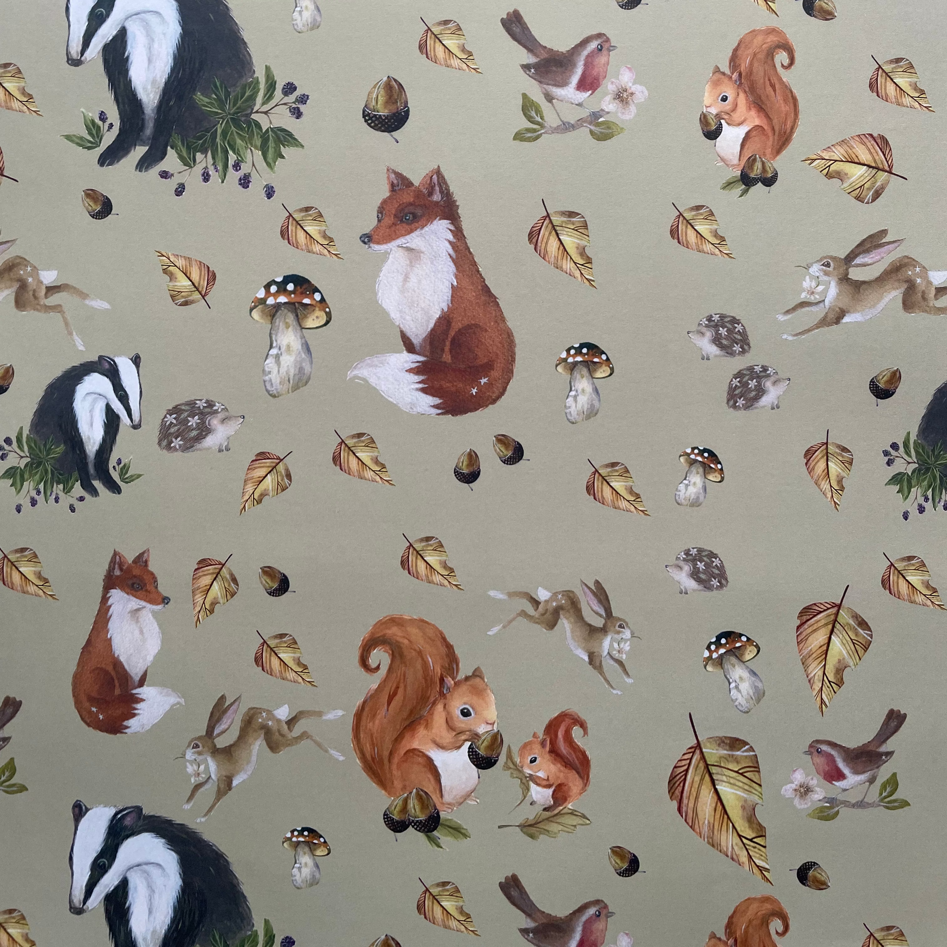Patterned fabric with forest animals and leaves on a light green background