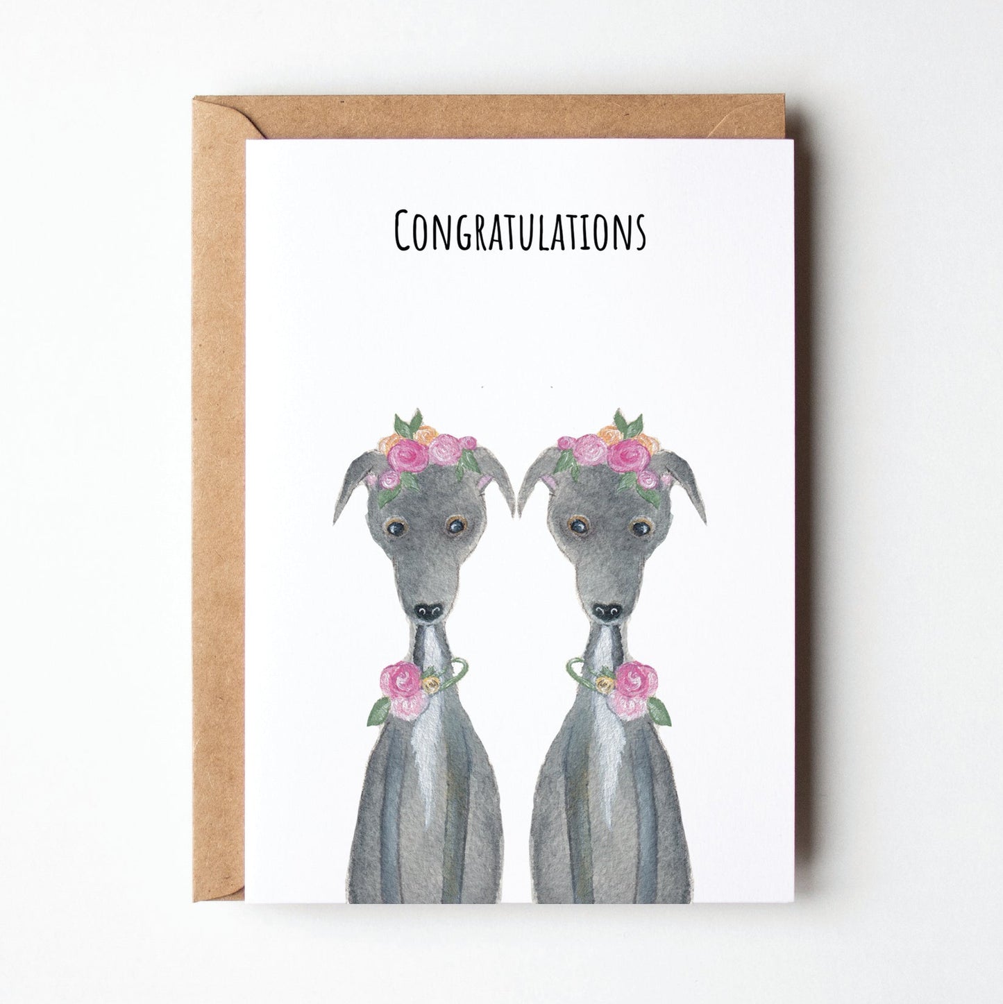 Greeting card with two greyhound dogs wearing flower collars and 'Congratulations' text on a white background.