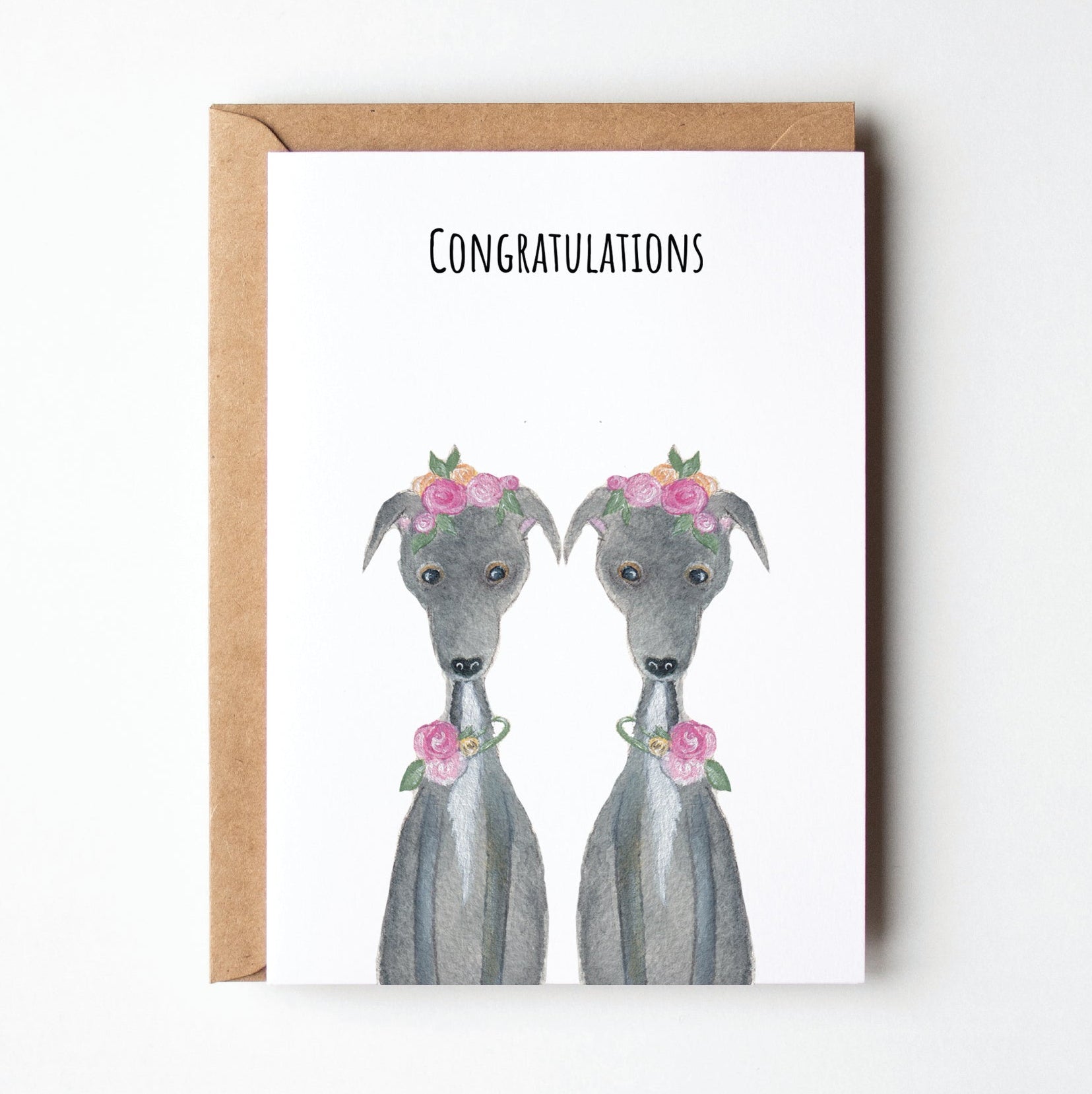 Greeting card with two greyhound dogs wearing flower collars and 'Congratulations' text on a white background.