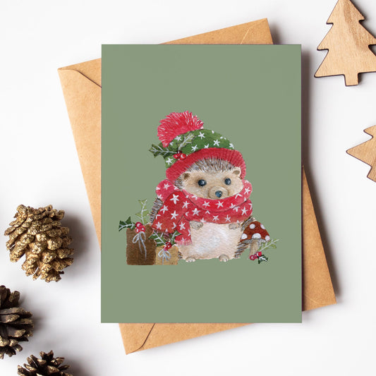 Christmas-themed greeting card with a hedgehog illustration, surrounded by pinecones and wooden trees on a white background.