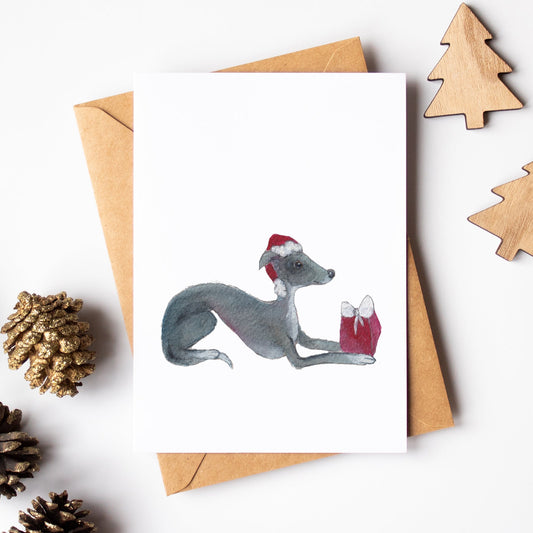Christmas card with a dog and gift, surrounded by decorative items on a white background